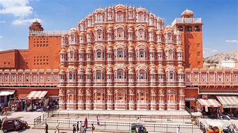 Also known as the "Palace of Winds," Hawa Mahal is a quintessential example of Rajput architecture. This stunning five-story pink sandstone structure is famous for its 953 small windows, or jharokhas, which were designed to allow royal ladies to observe street festivities while remaining unseen. Its unique honeycomb-like façade is a visual treat for architecture enthusiasts.